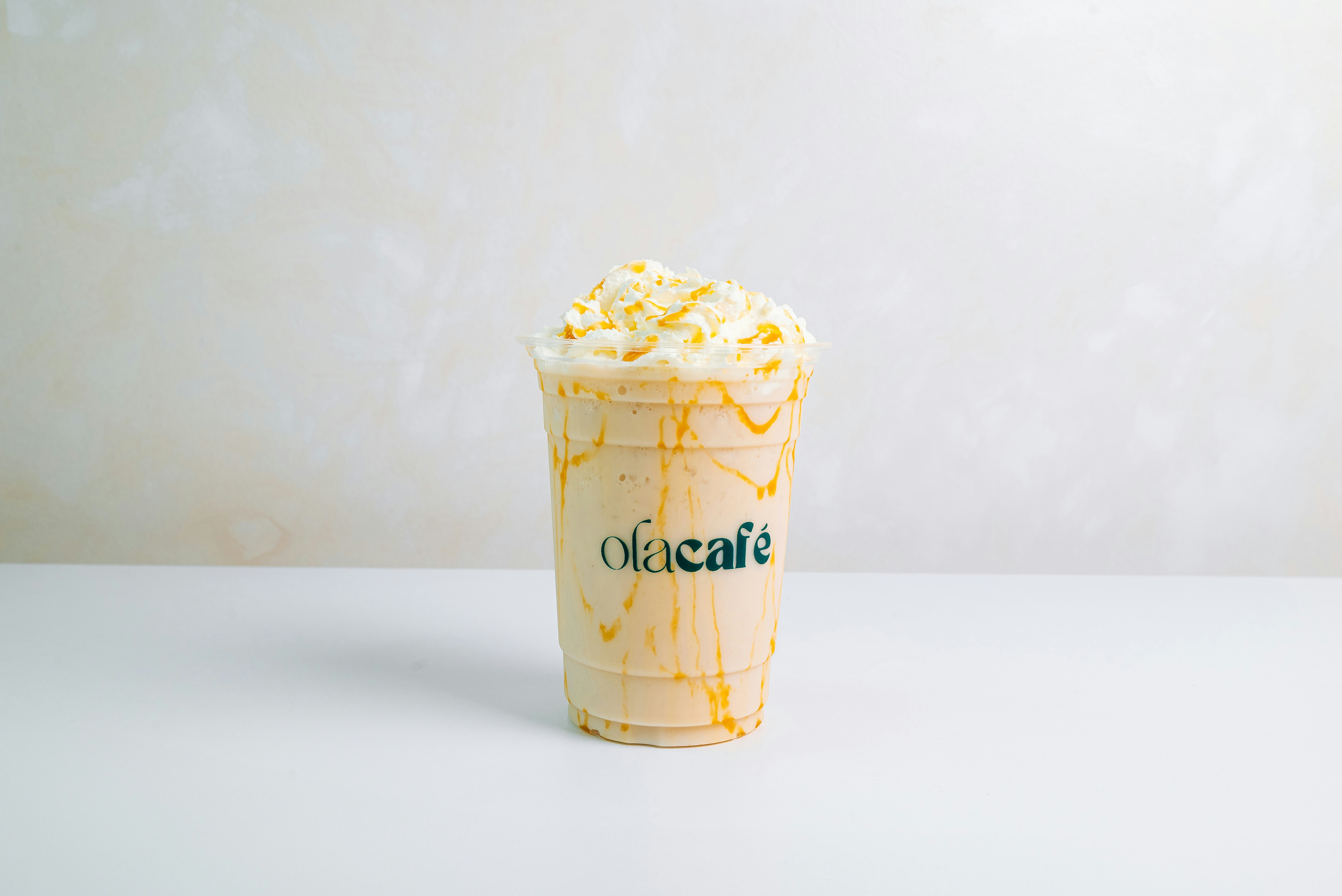 Thick caramel milkshake with whipped cream and caramel drizzle, moody dark background