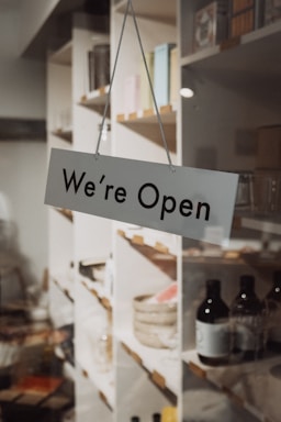 A sign hanging from the side of a glass door