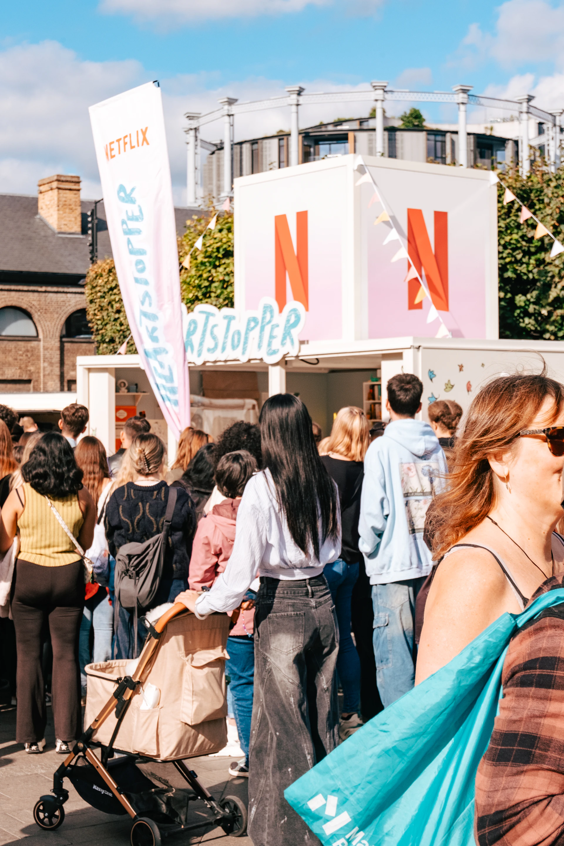 A crowd of people standing around a food stand