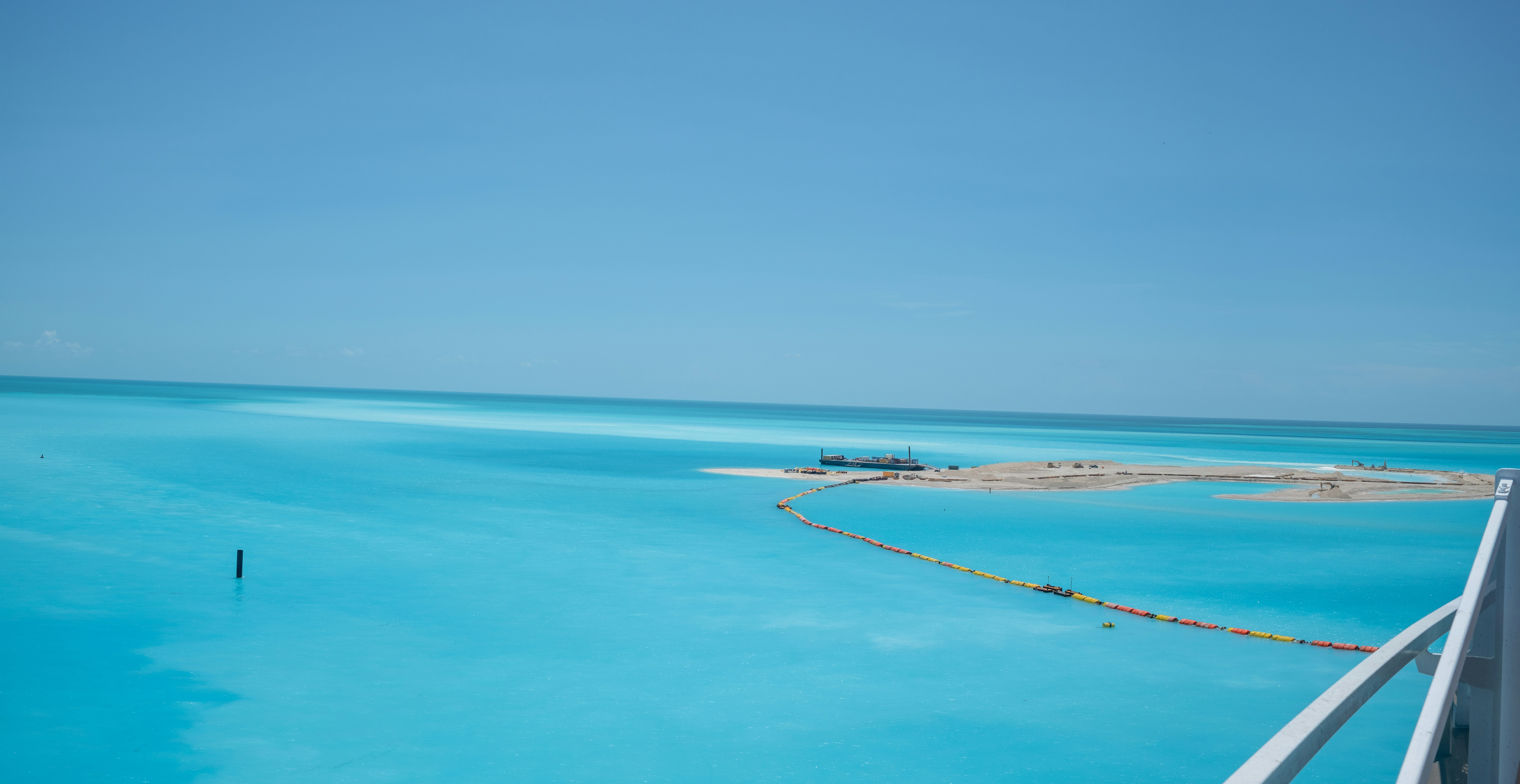 A large body of water with a bridge in the middle of it, MSC Marine Bilogical Island, Ocean Cay, The Bahamas
