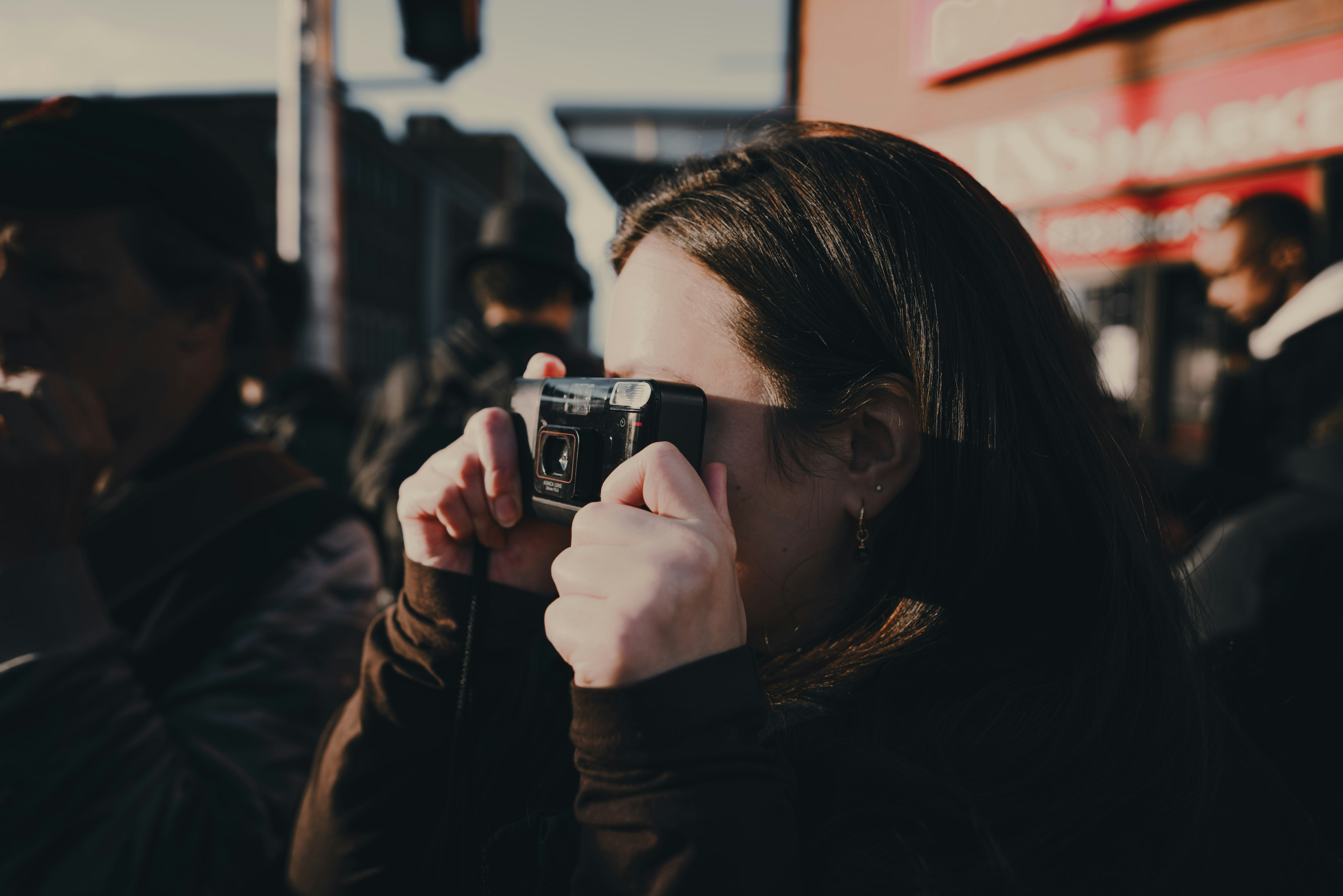 A woman holding a camera up to her face