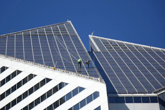 A man on a ladder working on the roof of a building