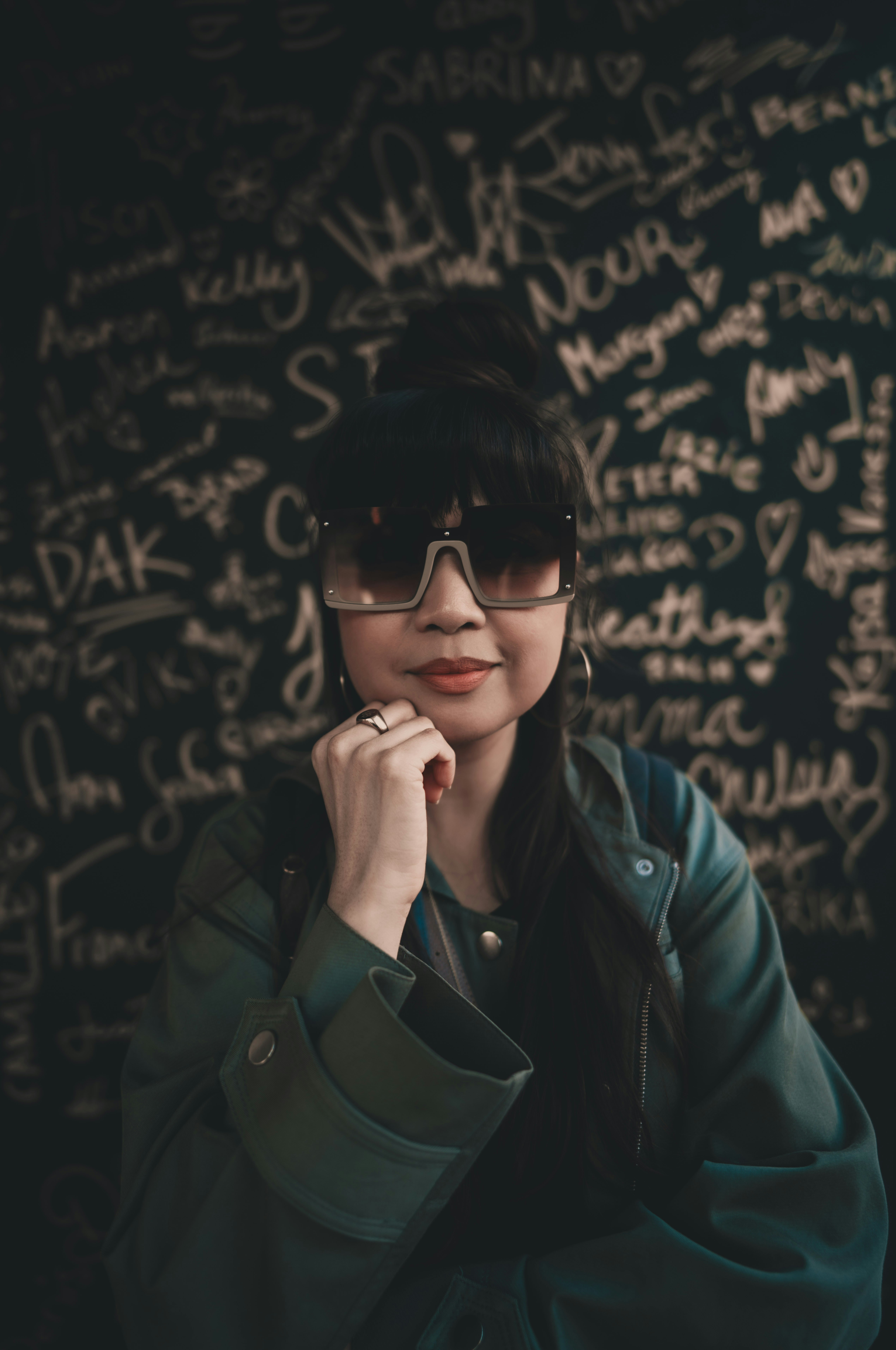 A woman wearing glasses and a green jacket