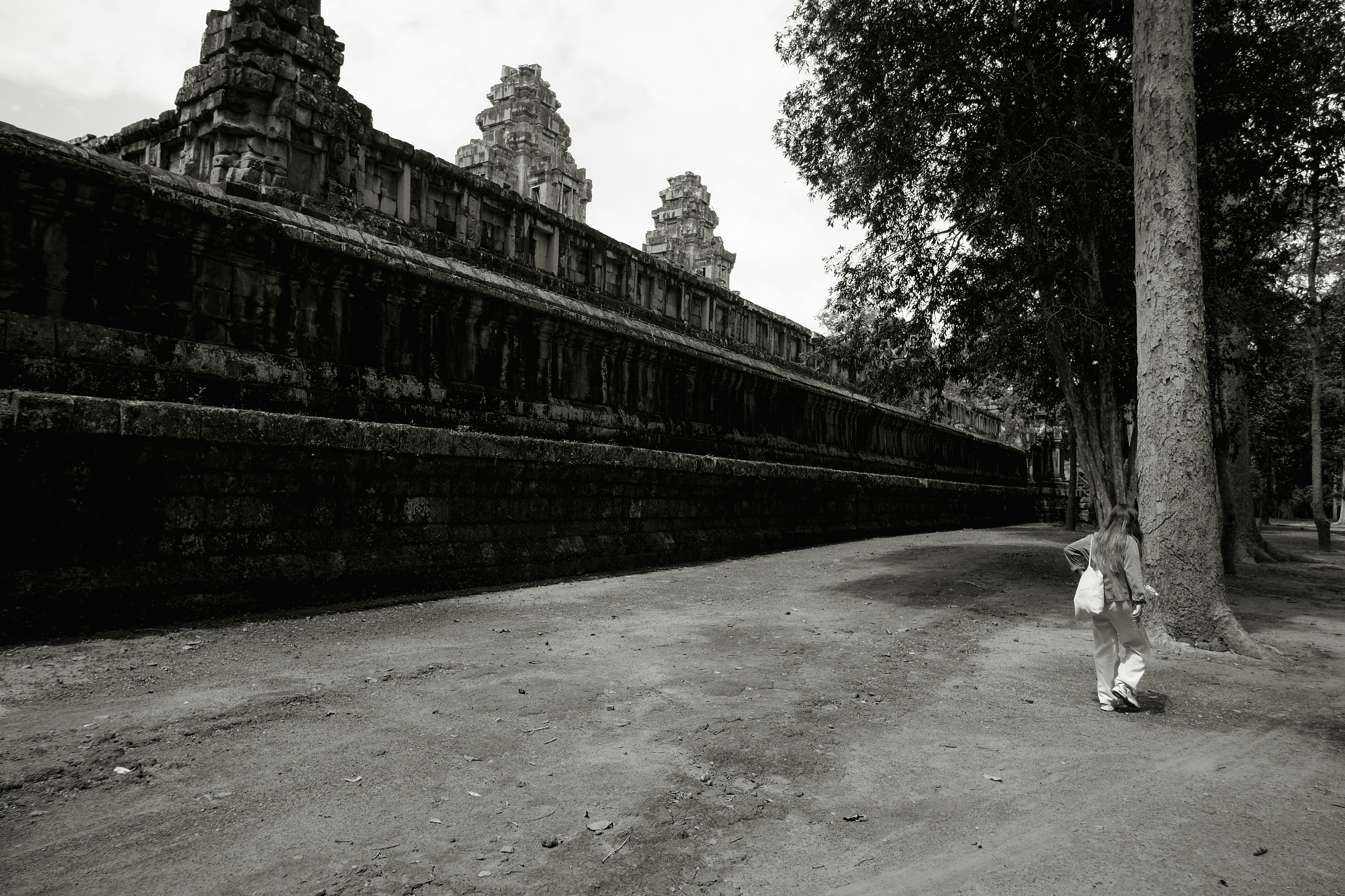A black and white photo of a person walking down a street