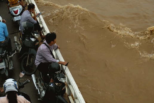A group of people riding bikes down a flooded street