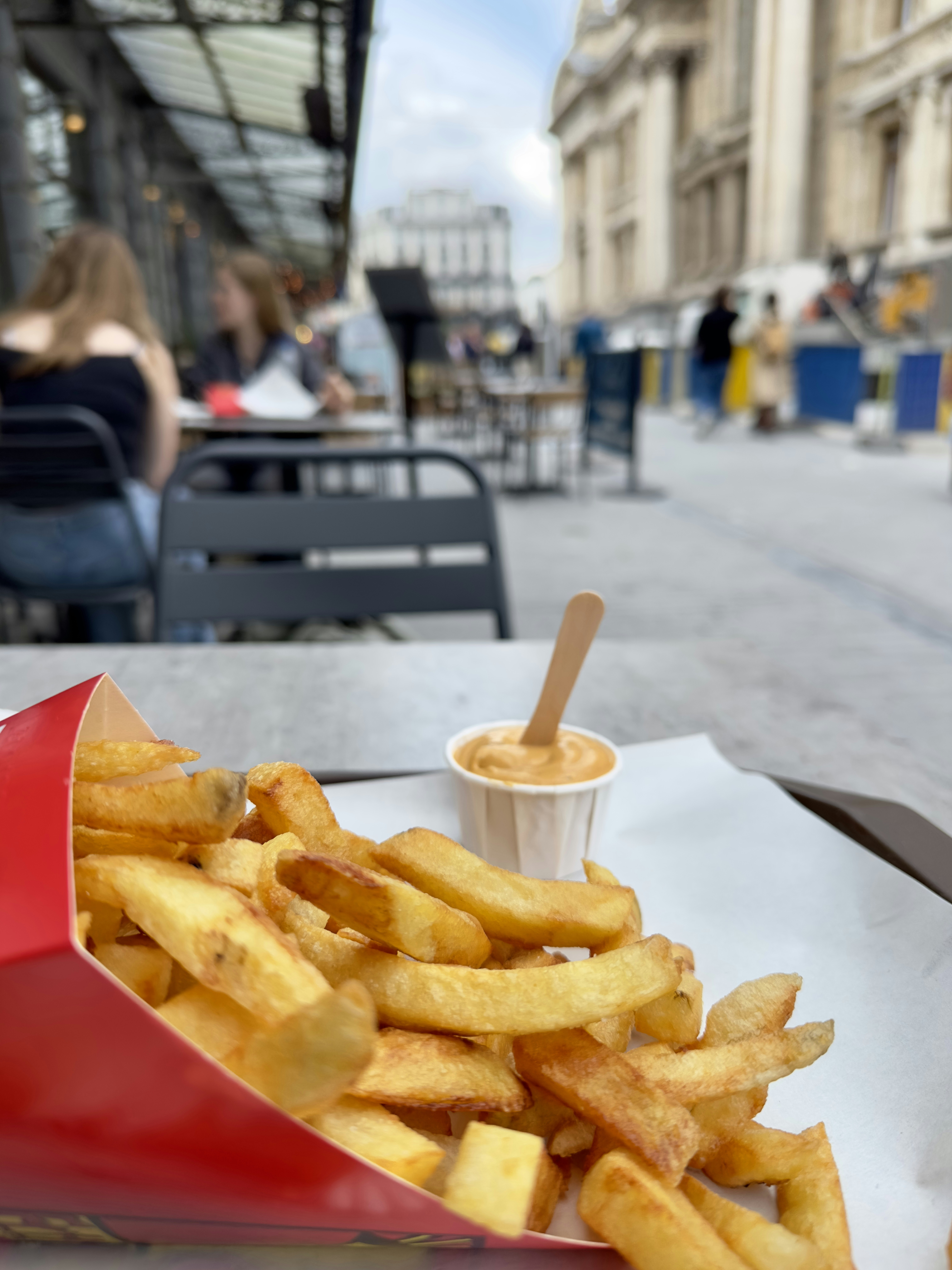 Golden crispy french fries in red basket with dipping sauce