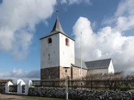 A church with a steeple on a cloudy day