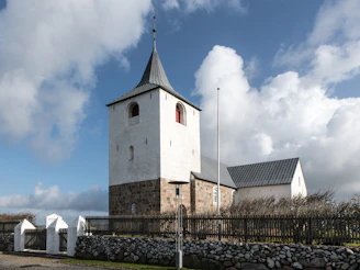 A church with a steeple on a cloudy day