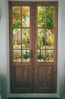 A pair of wooden doors sitting inside of a room