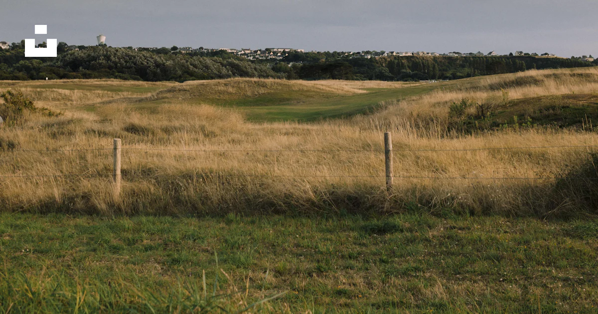 A large open field with a fence in the middle of it photo – Free Field ...