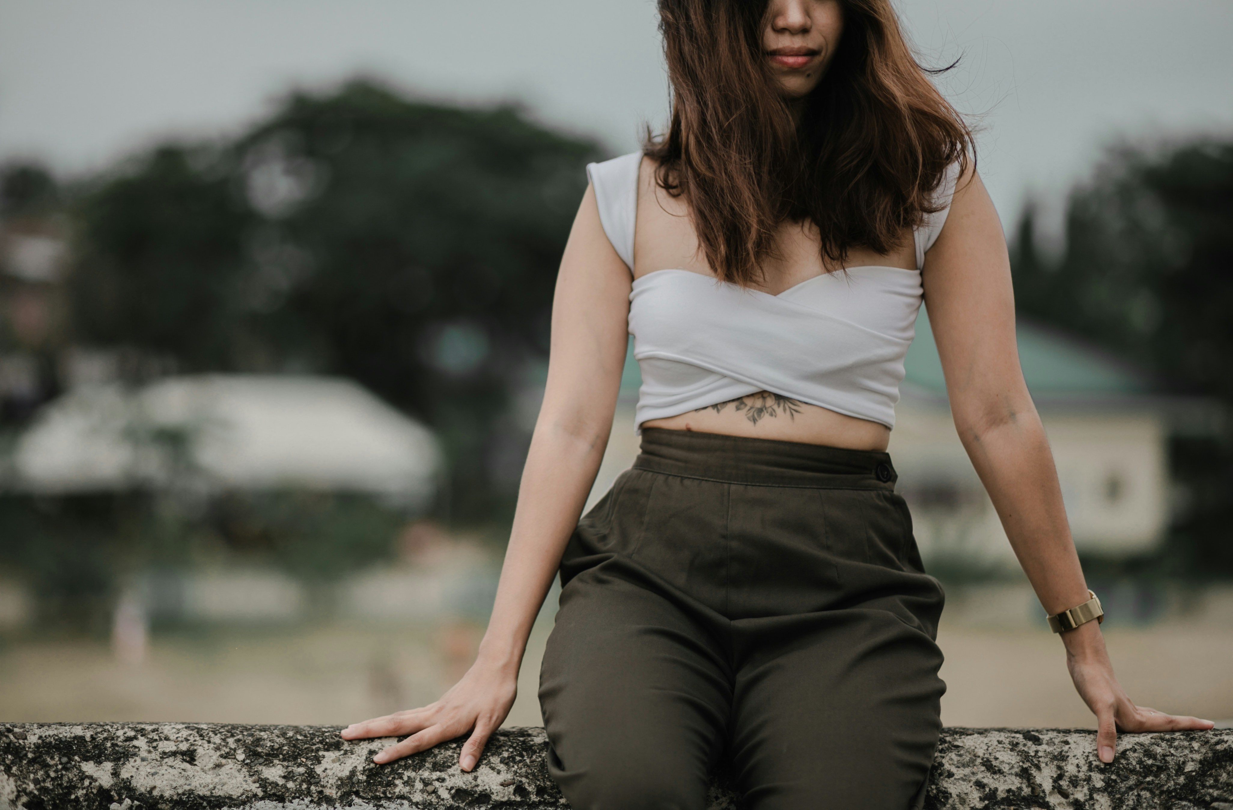 A woman sitting on top of a stone wall