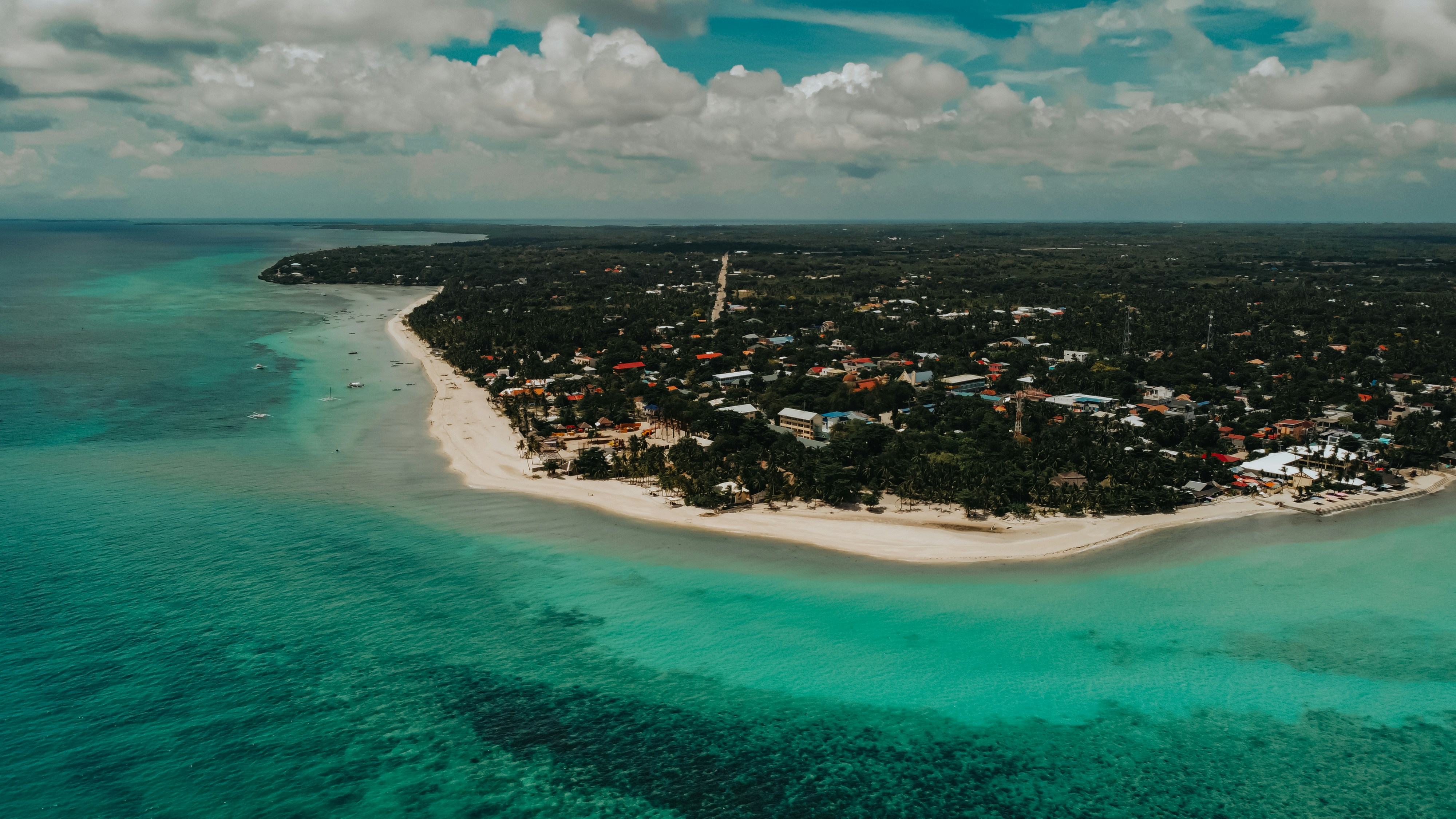 Aerial view of lush tropical island coastline with clear blue ocean