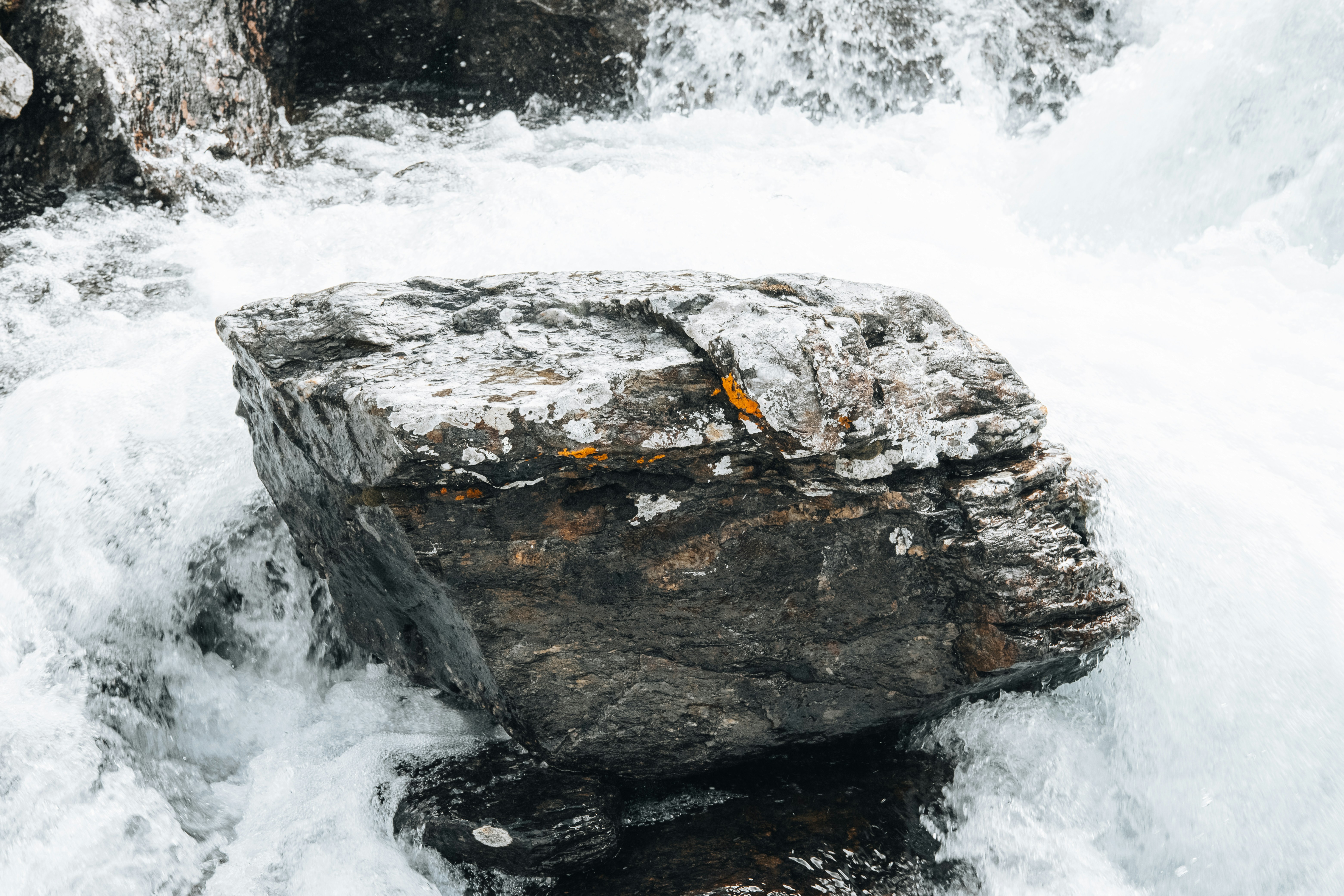 A large rock in the middle of a body of water