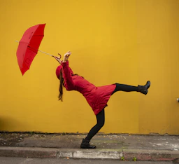 A woman in a red dress holding a red umbrella