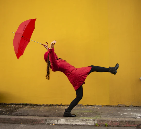 A woman in a red dress holding a red umbrella