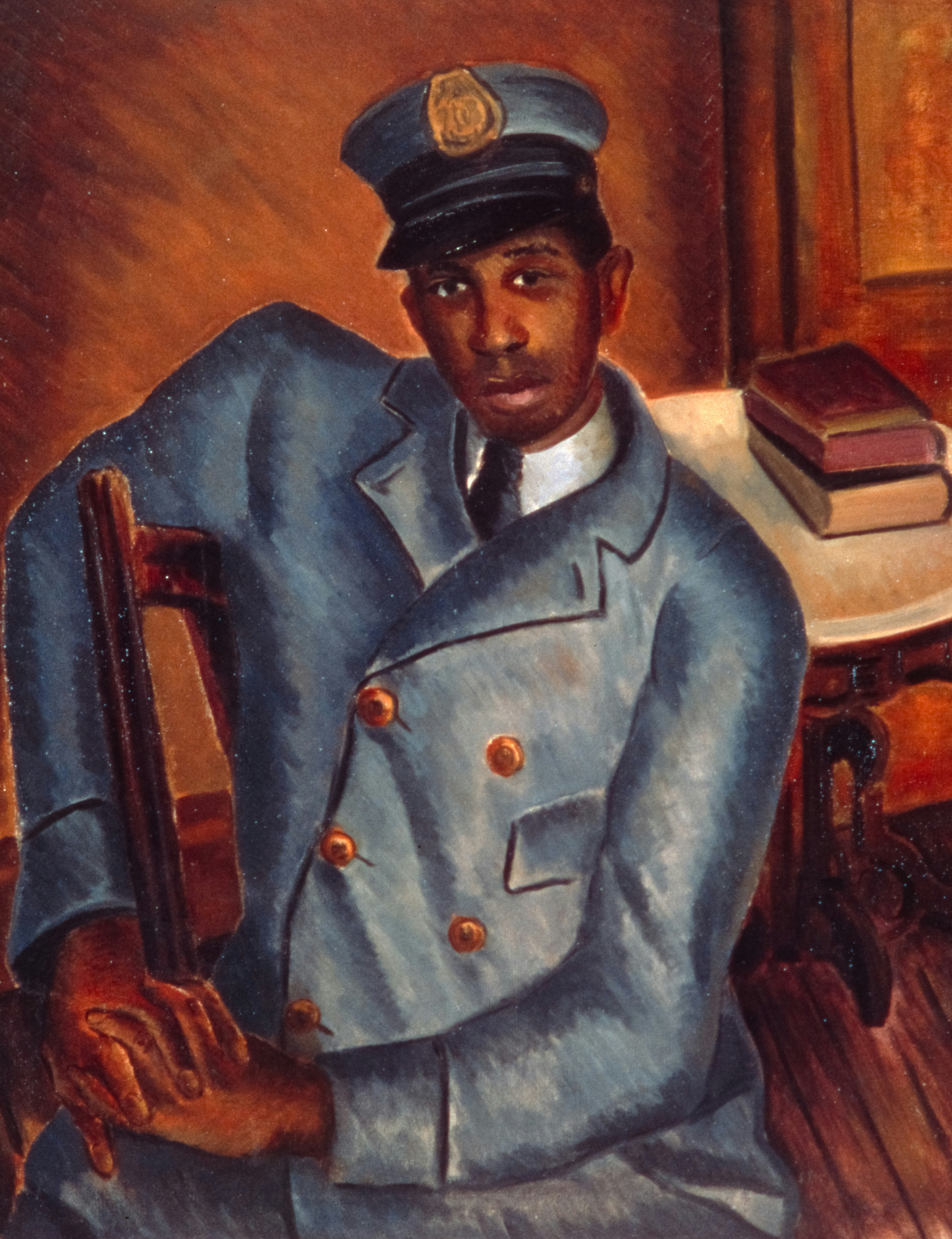 Man in a blue uniform sits in a chair.