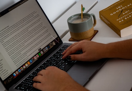 A person typing on a laptop on a desk