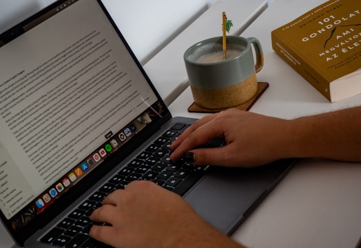 A person typing on a laptop on a desk
