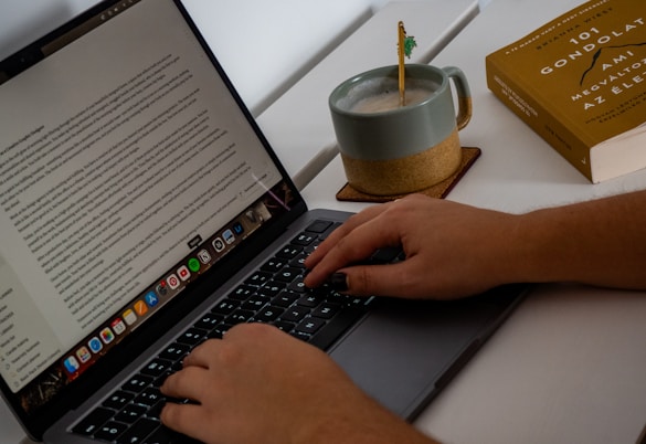 A person typing on a laptop on a desk