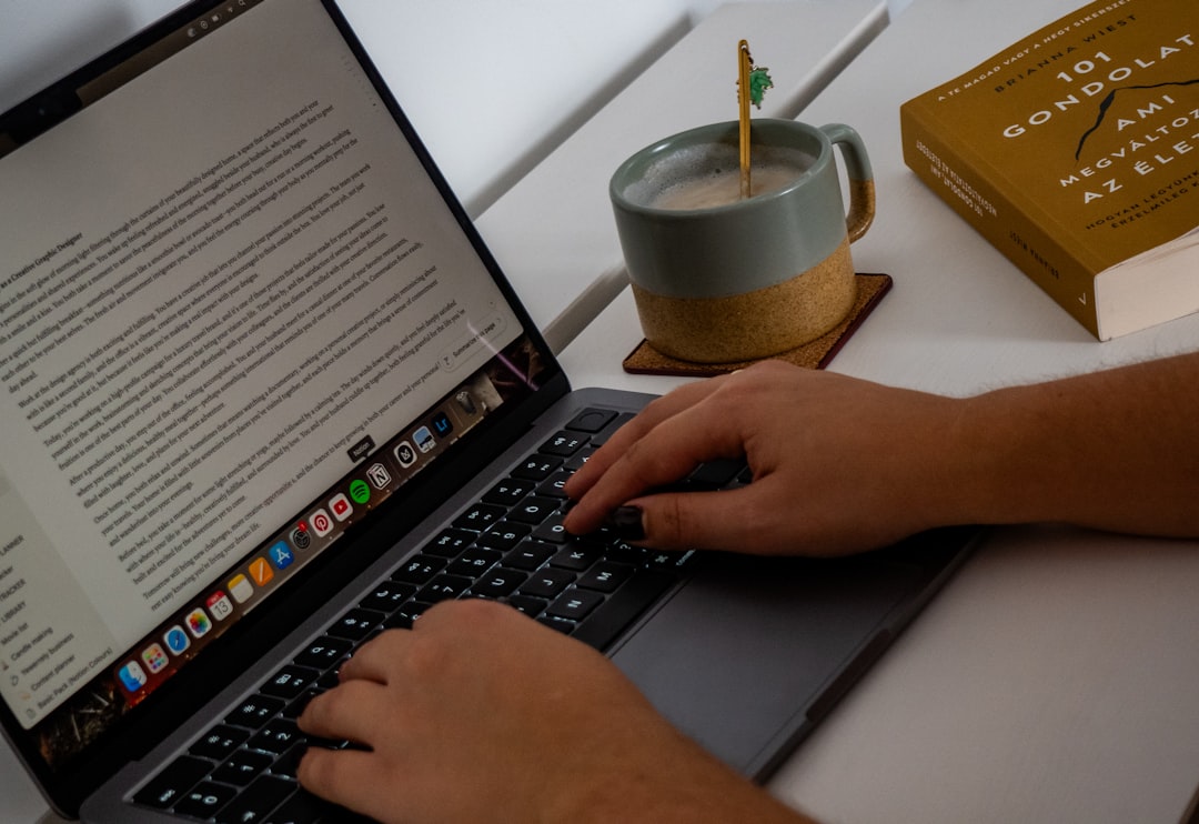 A person typing on a laptop on a desk