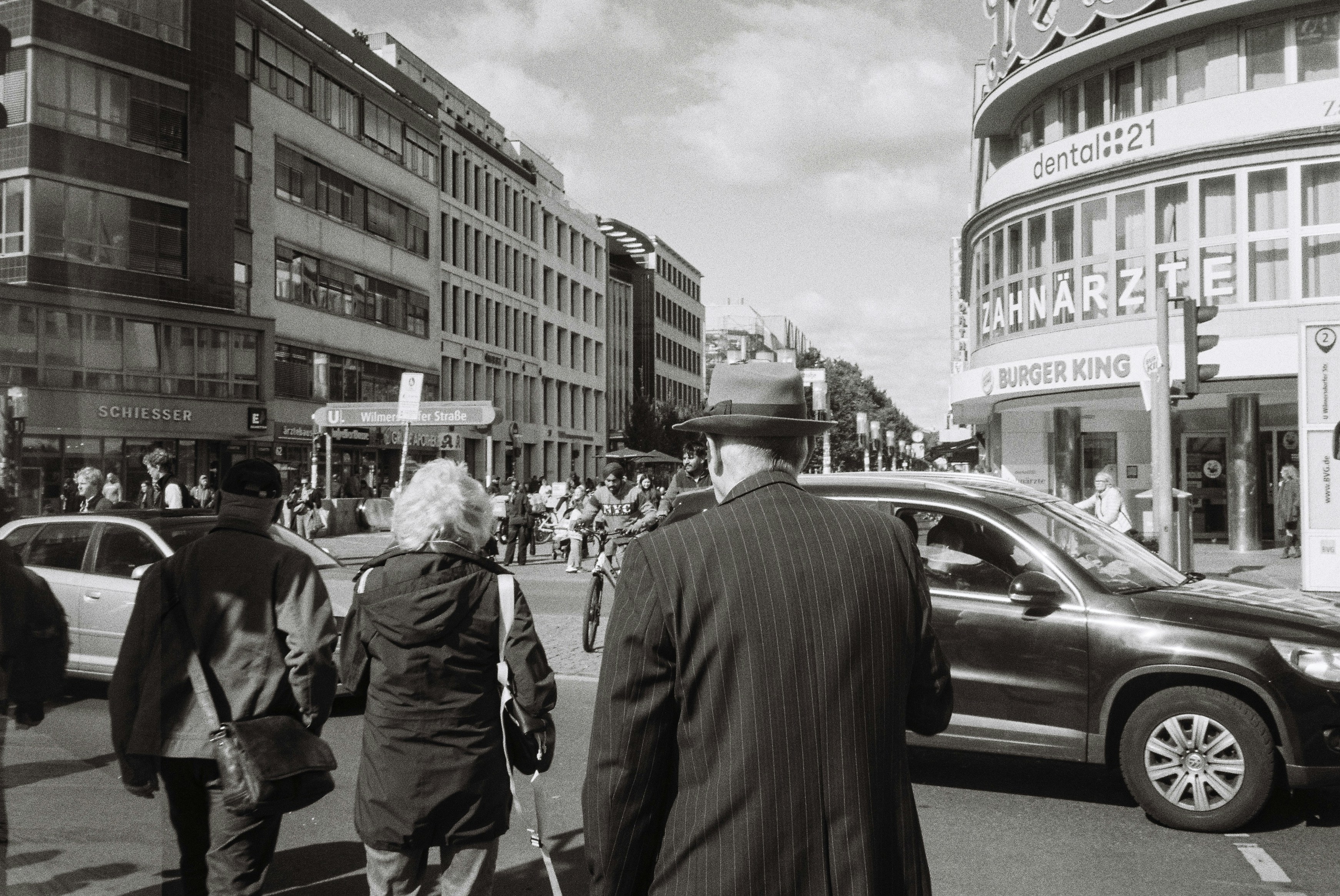 A black and white photo of people walking down the street