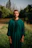 A man in a green outfit standing in a field