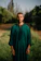 A man in a green outfit standing in a field