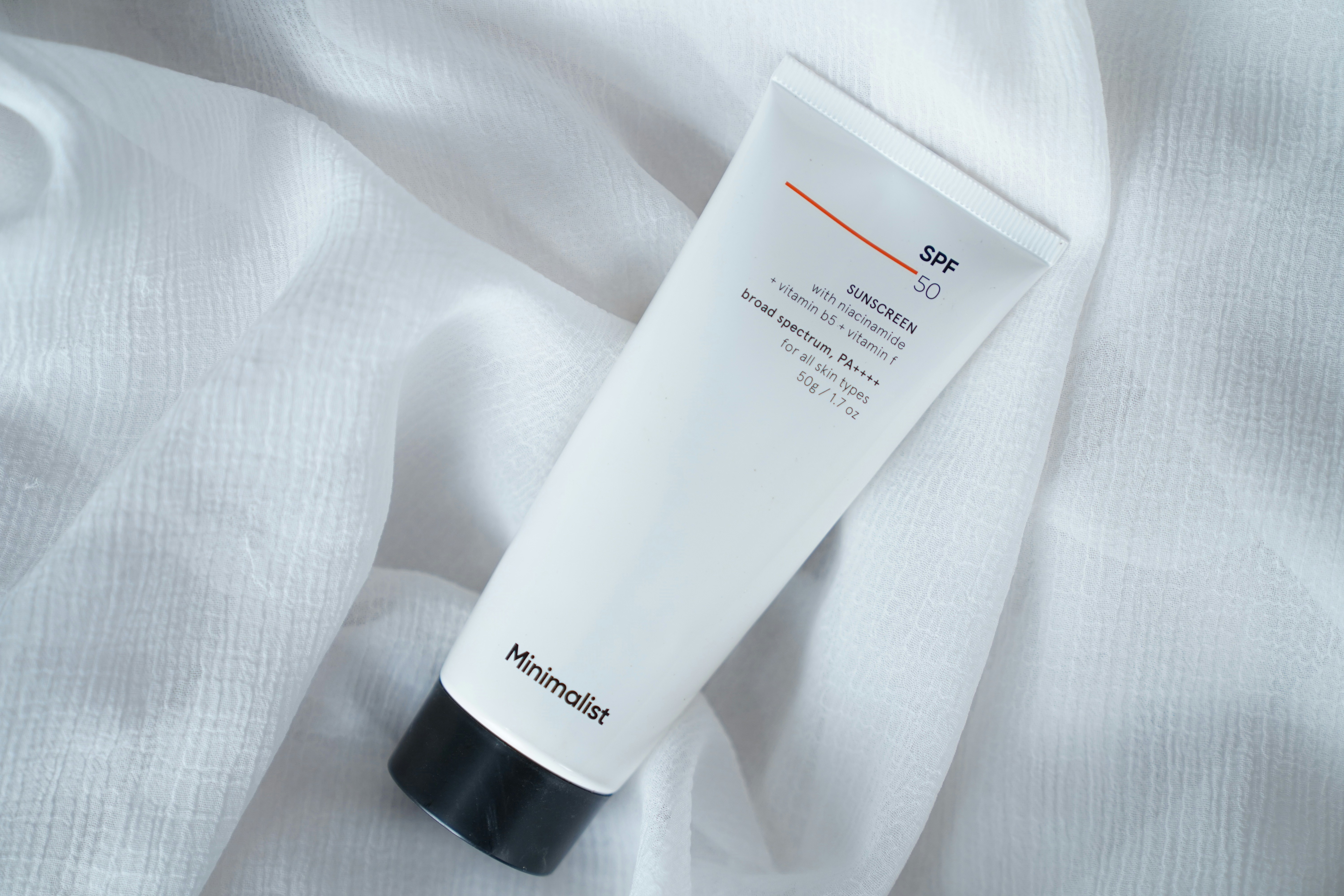 A tube of cream sitting on top of a white sheet