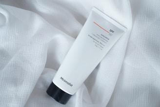 A tube of cream sitting on top of a white sheet