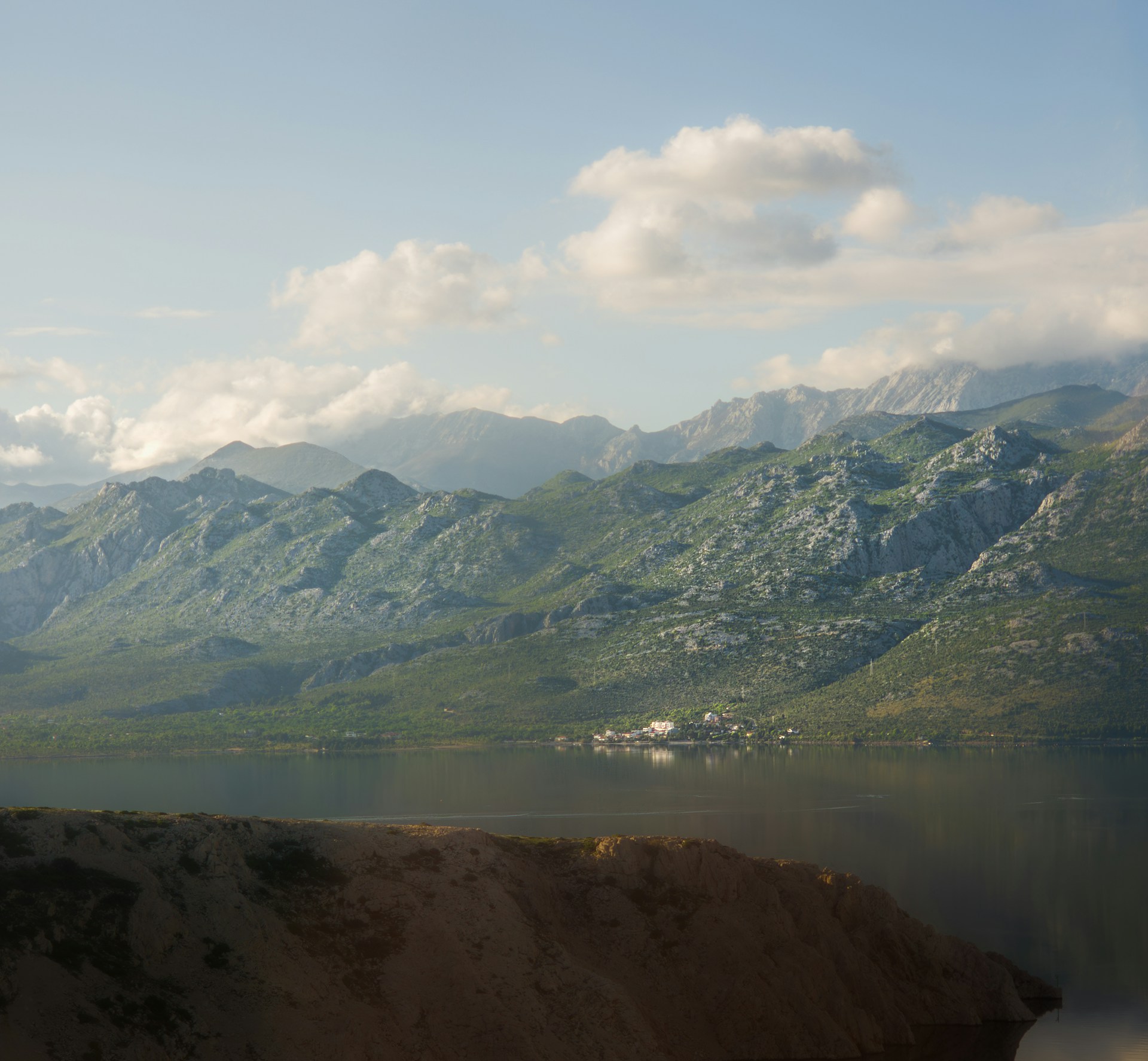 A view of a mountain range with a body of water in the foreground