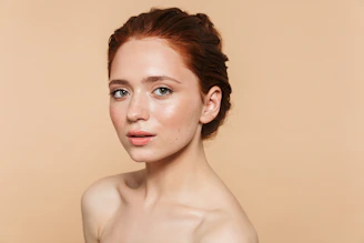A woman with red hair is posing for a picture