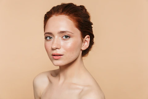 A woman with red hair is posing for a picture