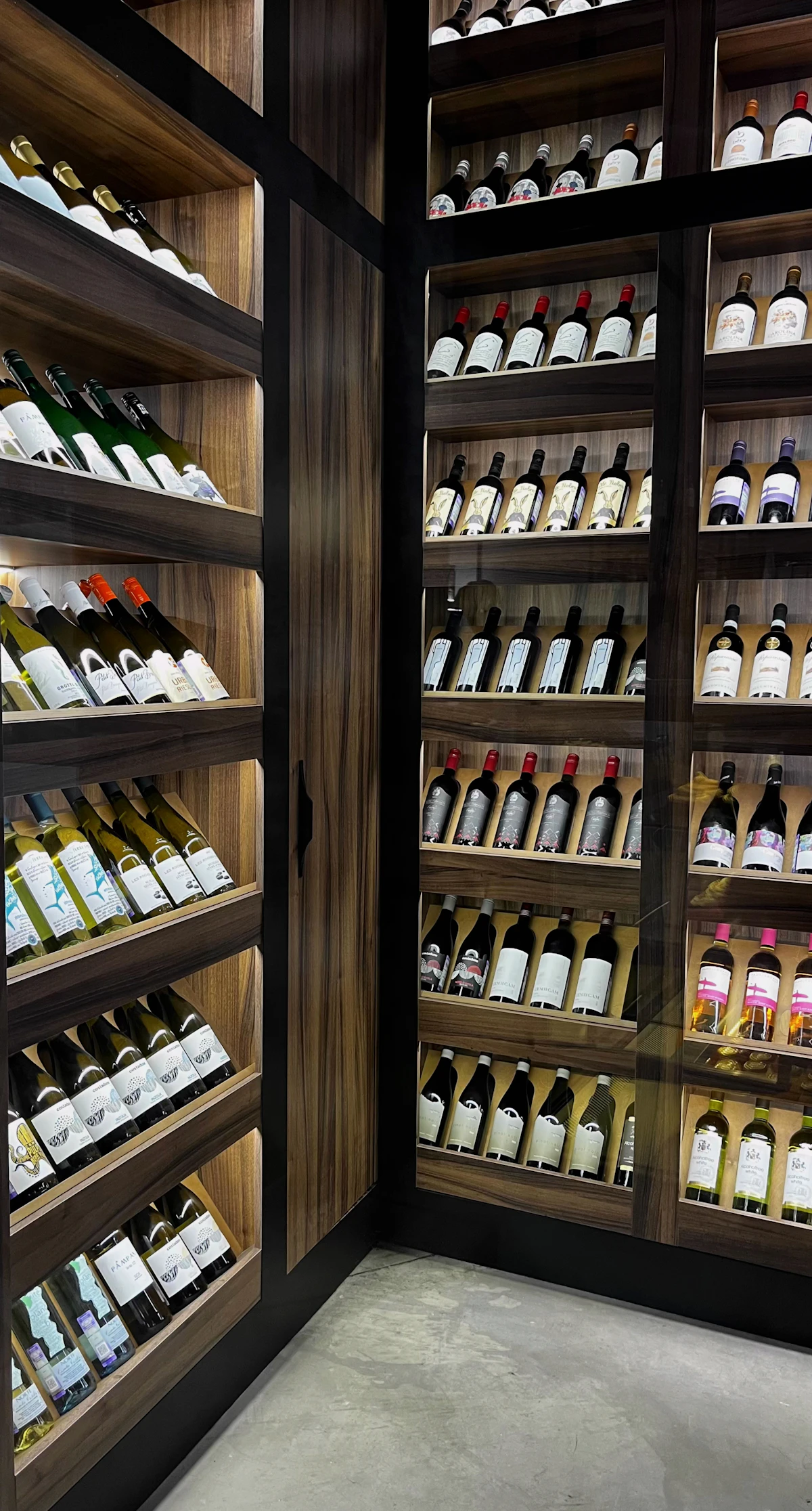 Built-in wine cooler cabinet stocked with bottles