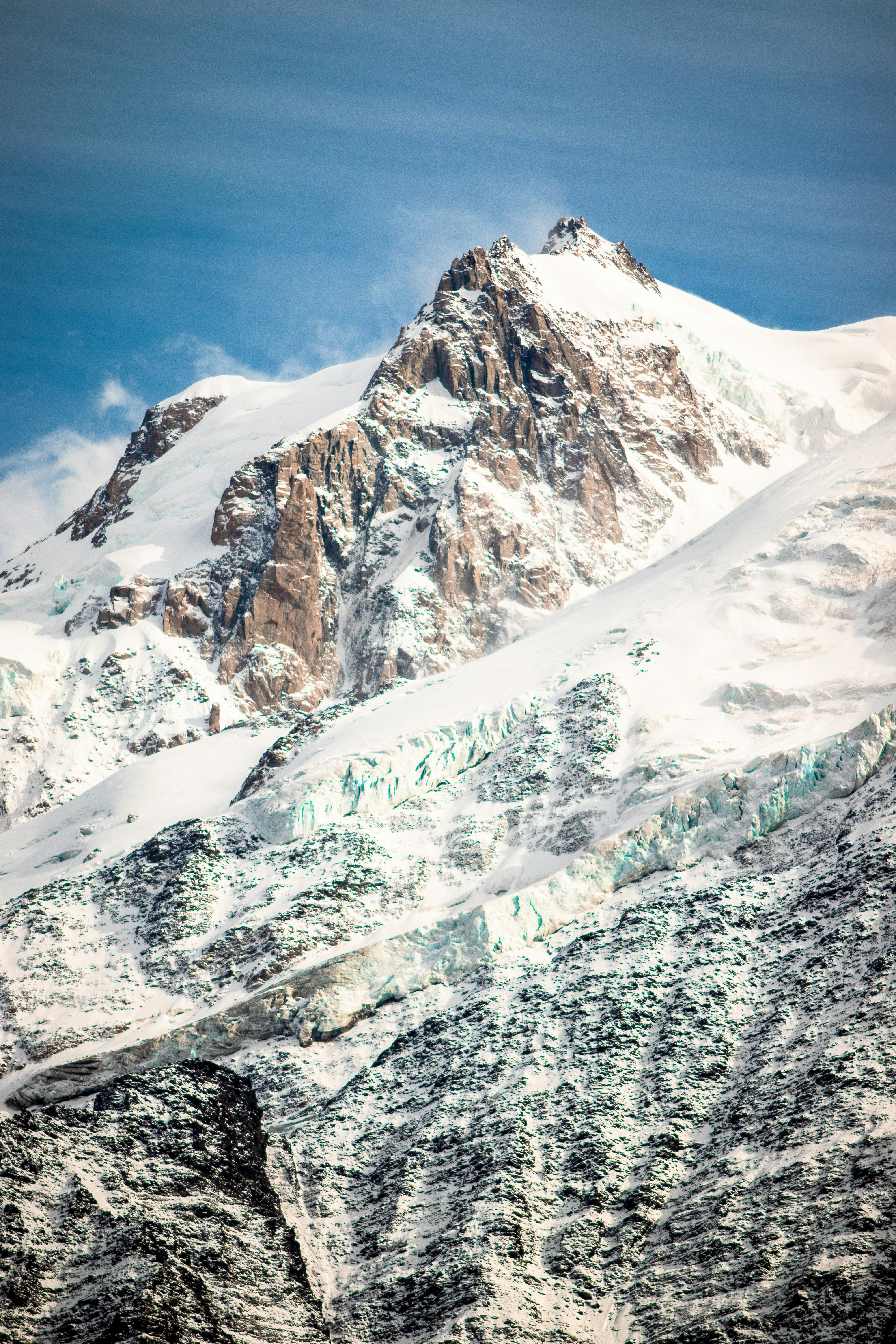 A mountain covered in snow under a blue sky