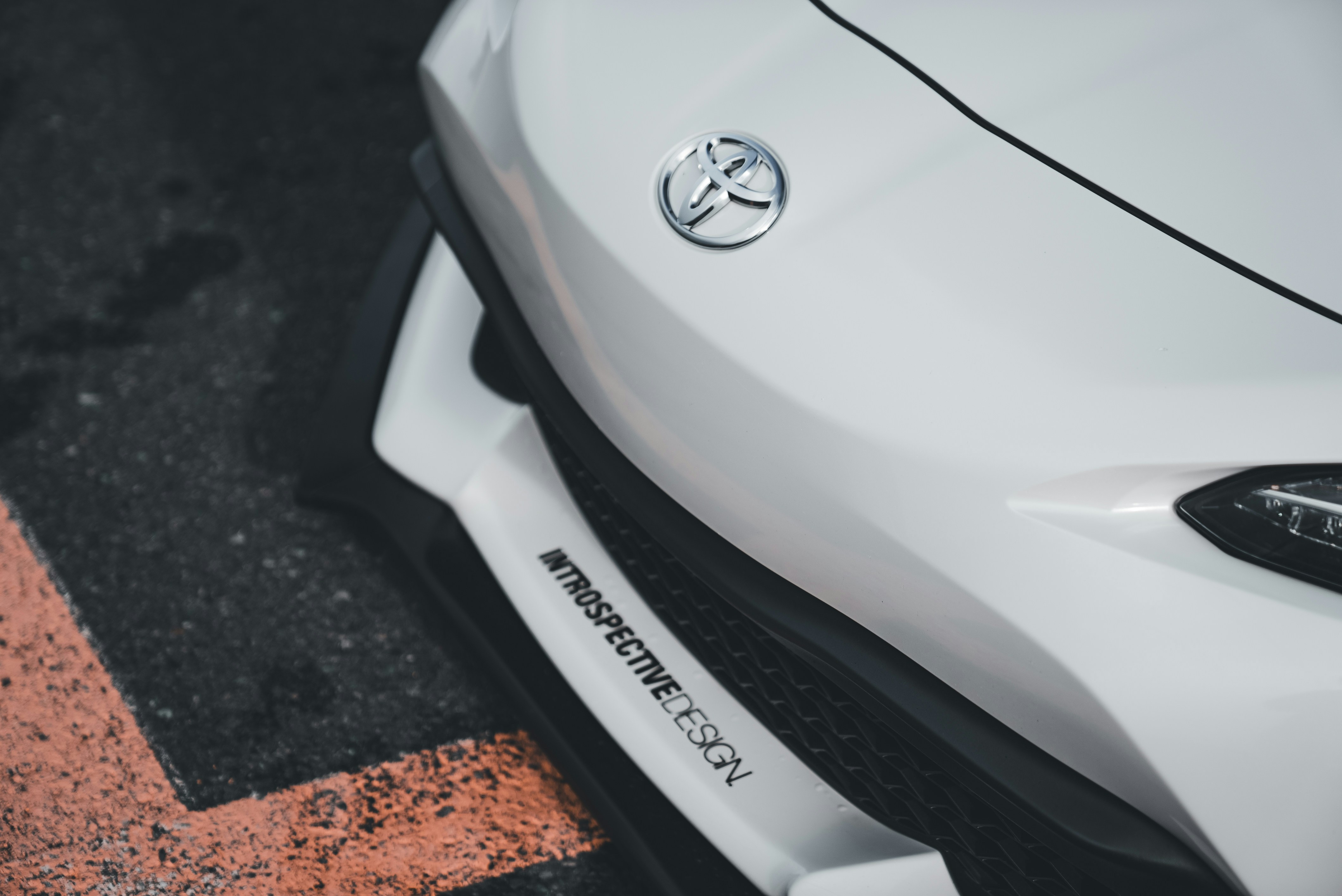 A close up of a white car parked in a parking lot