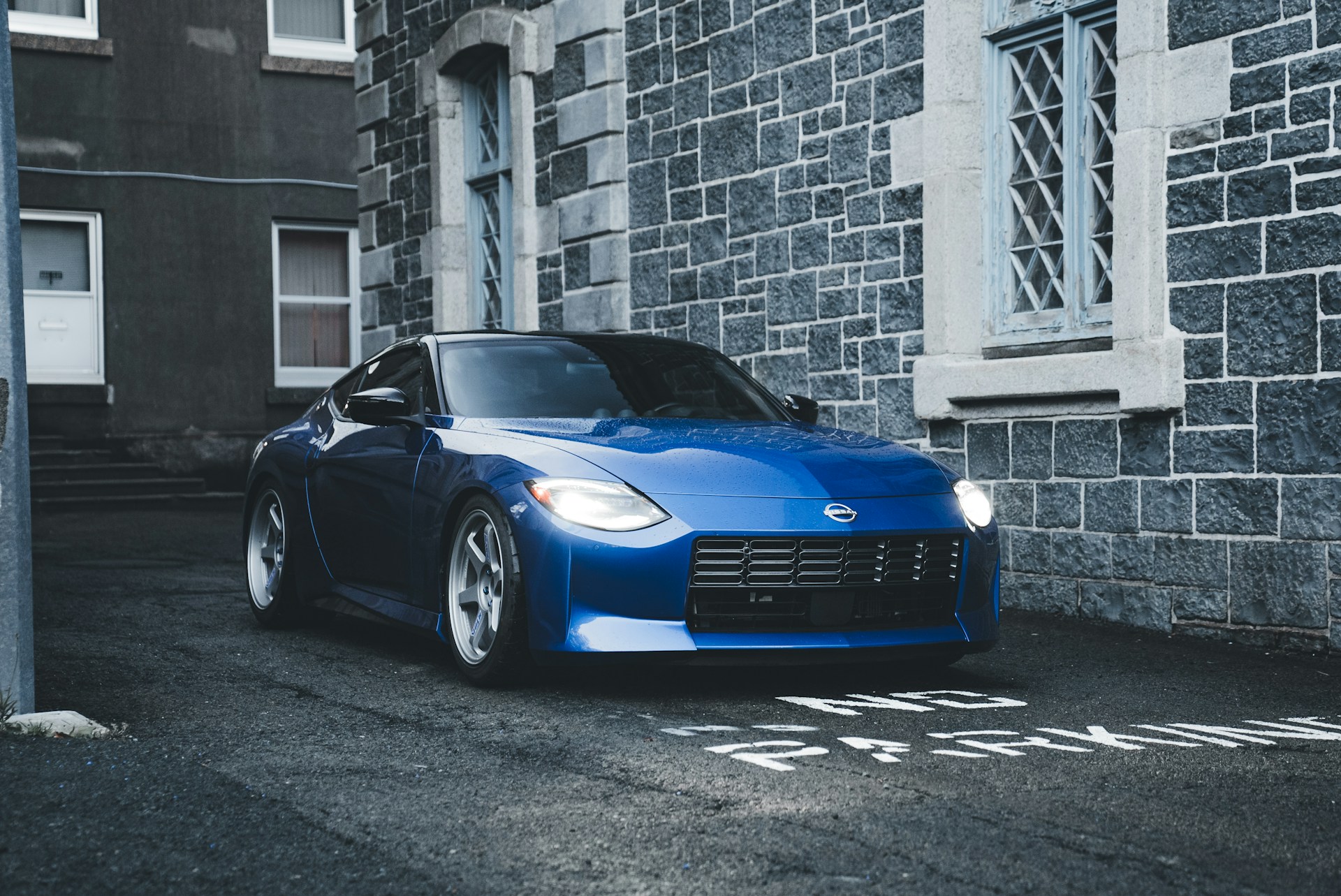 A blue sports car parked in front of a building