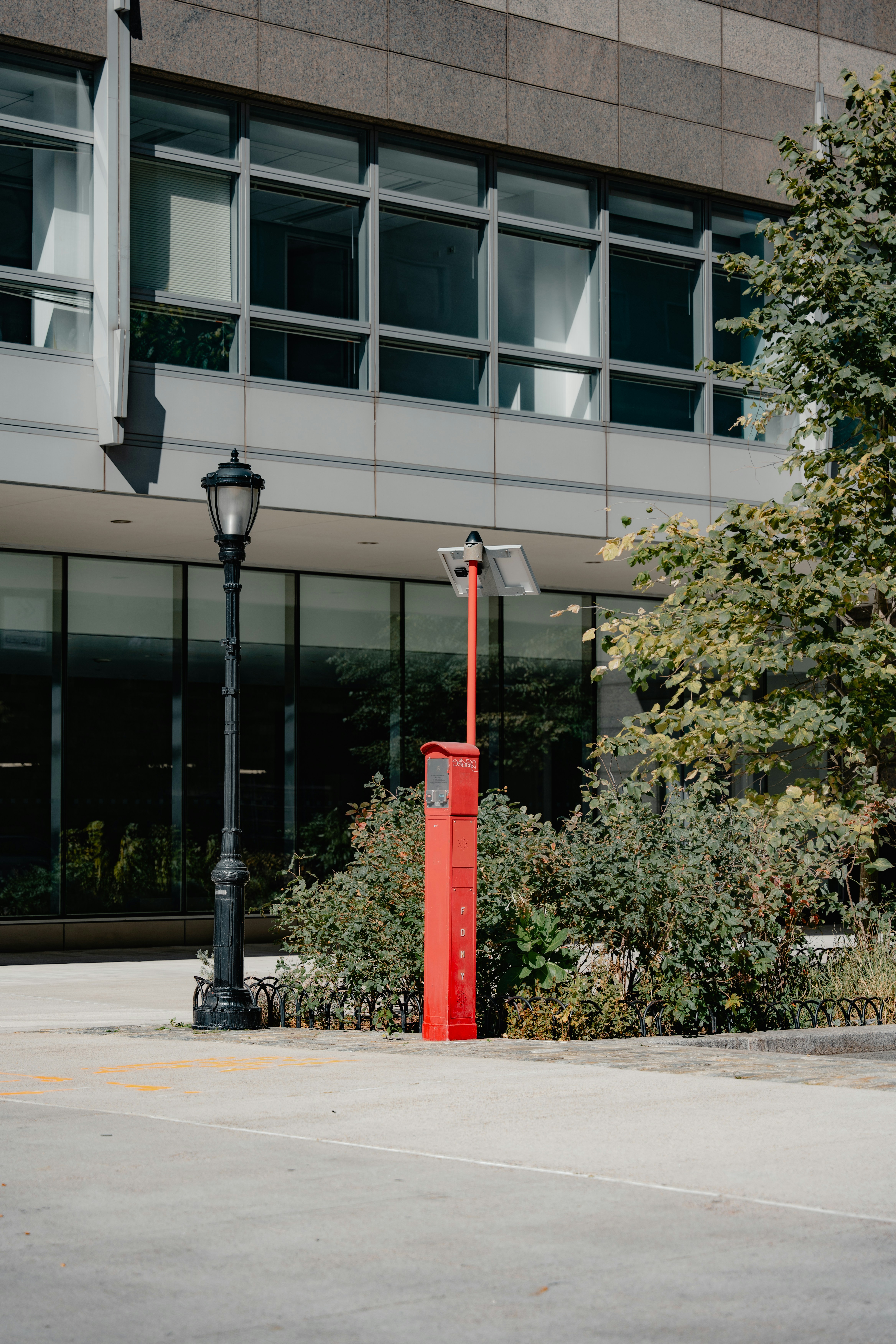 A red pole sitting in front of a tall building