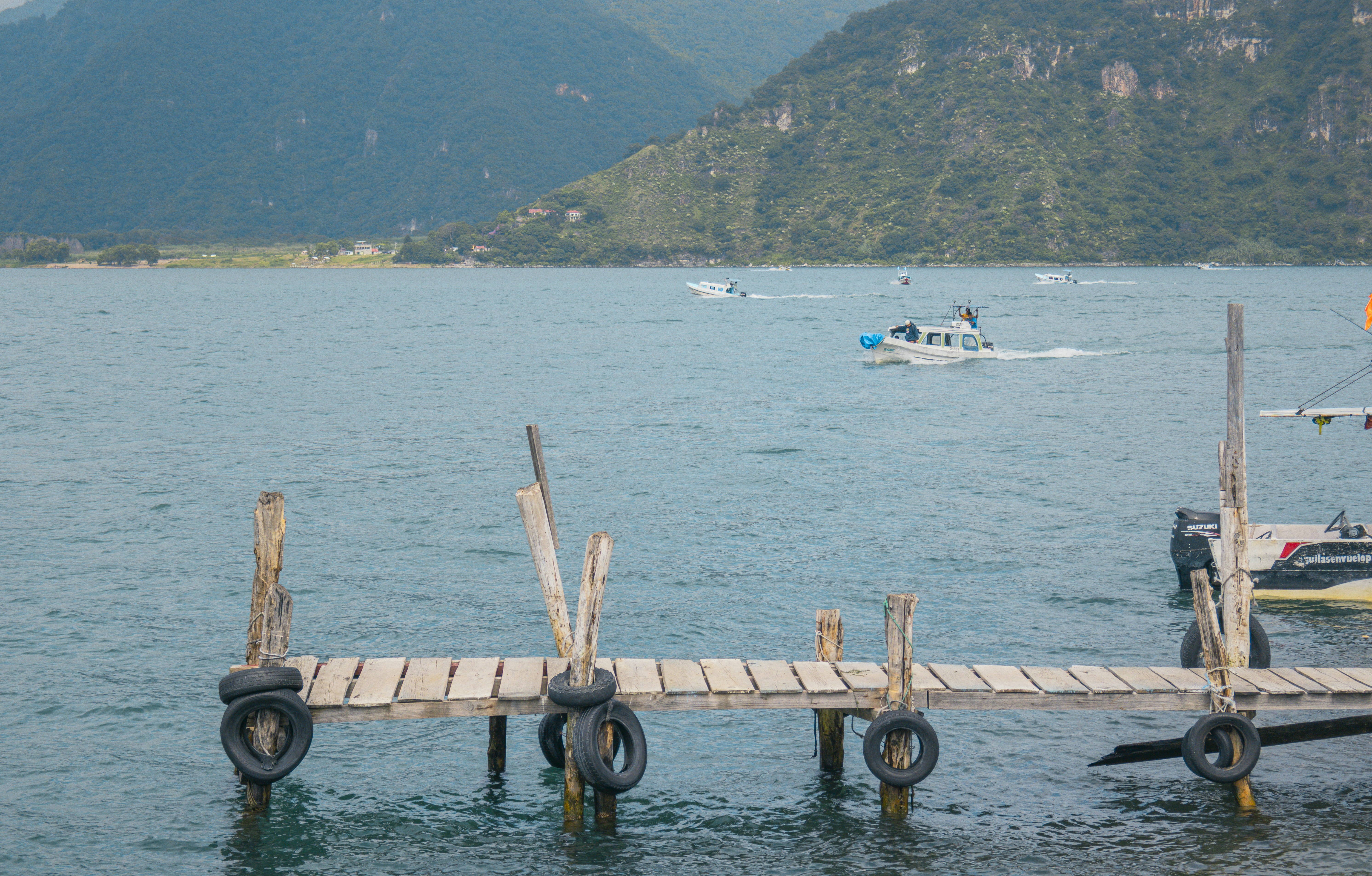 Fotomural A dock on a lake with a boat in the water