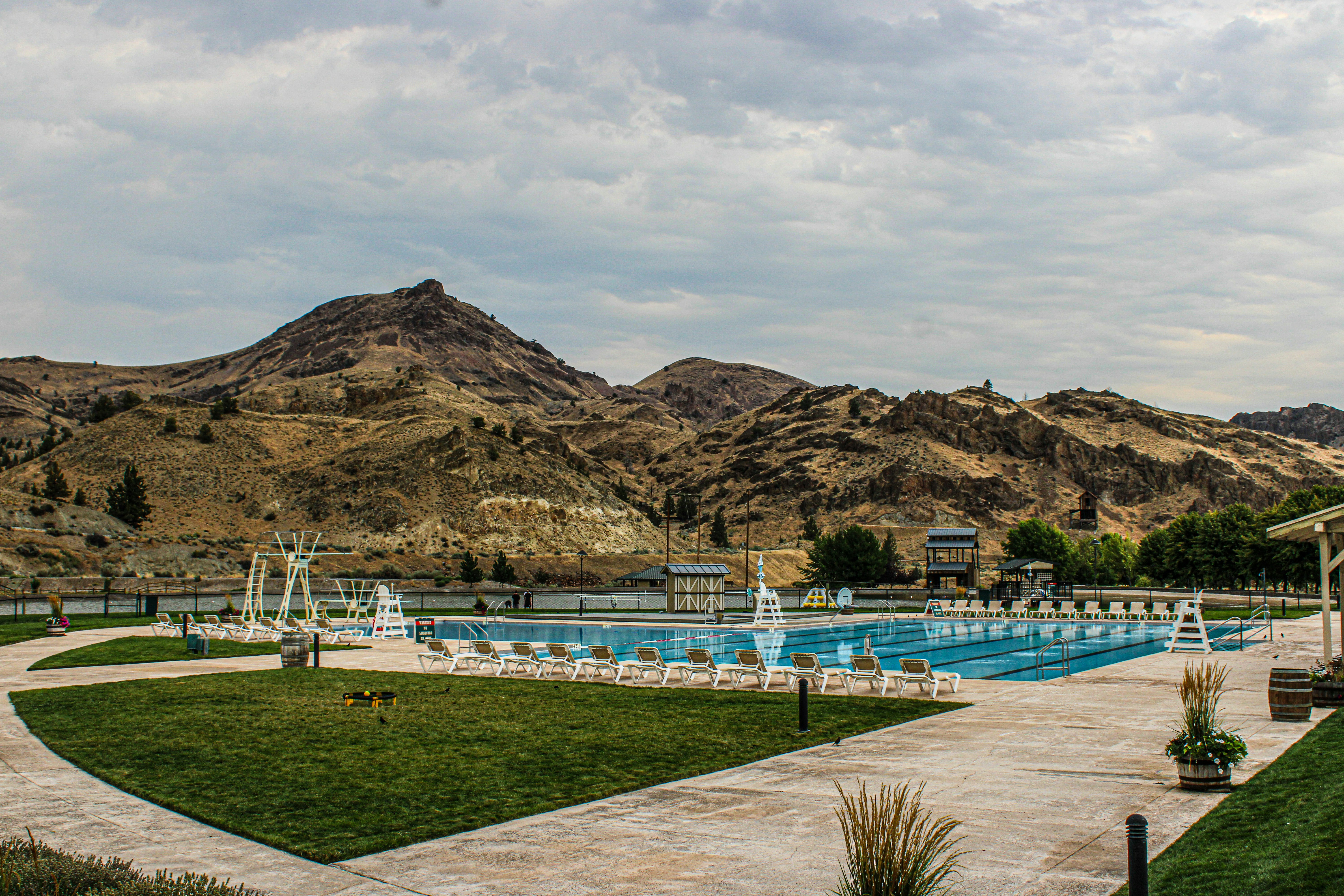 A large swimming pool surrounded by lush green grass, 