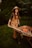 A woman is holding a wheelbarrow and smiling
