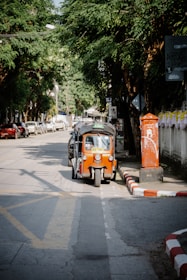 An orange and black car parked on the side of a road
