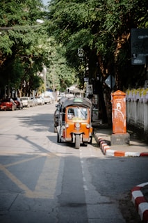 An orange and black car parked on the side of a road