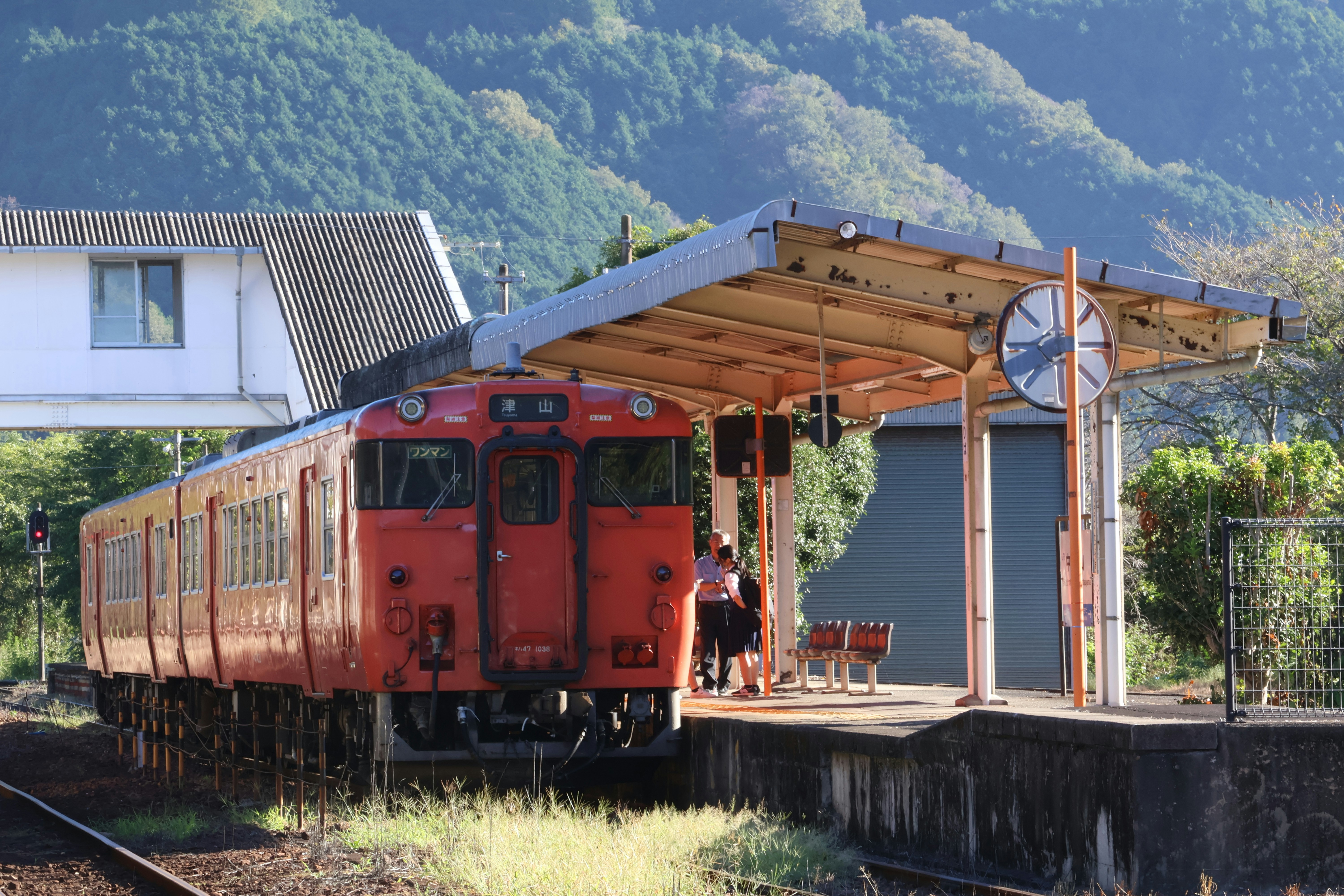 A red train traveling past a train station