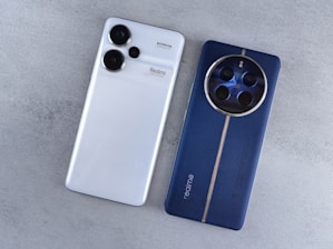A white and blue cell phone sitting next to each other