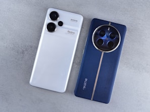 A white and blue cell phone sitting next to each other