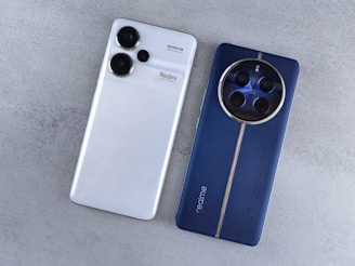 A white and blue cell phone sitting next to each other