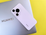 A white cell phone sitting on top of a laptop computer