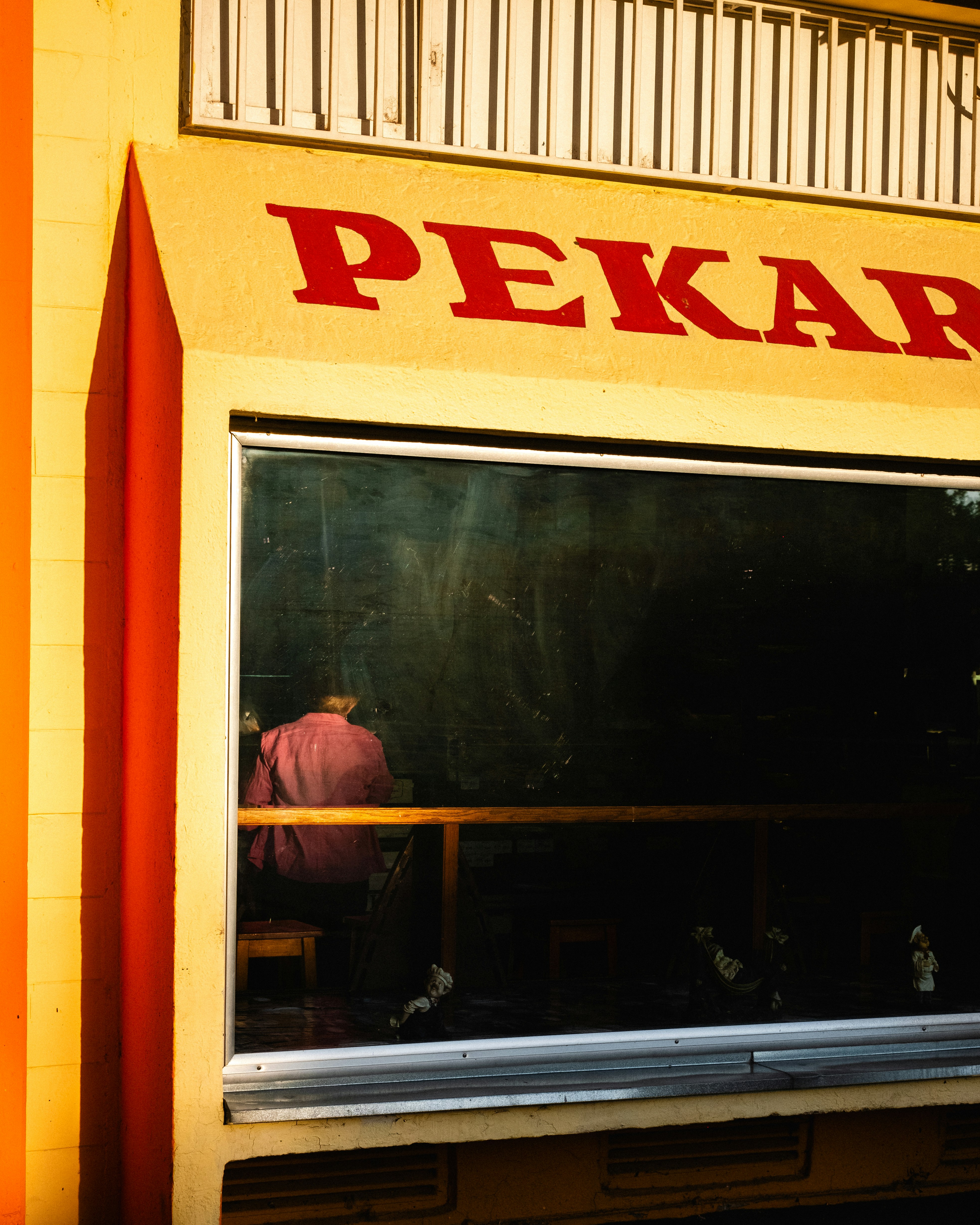 A store front with a reflection of a person in the window