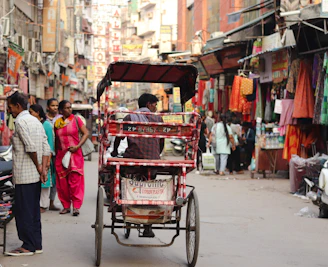 A man riding a cart down a busy street