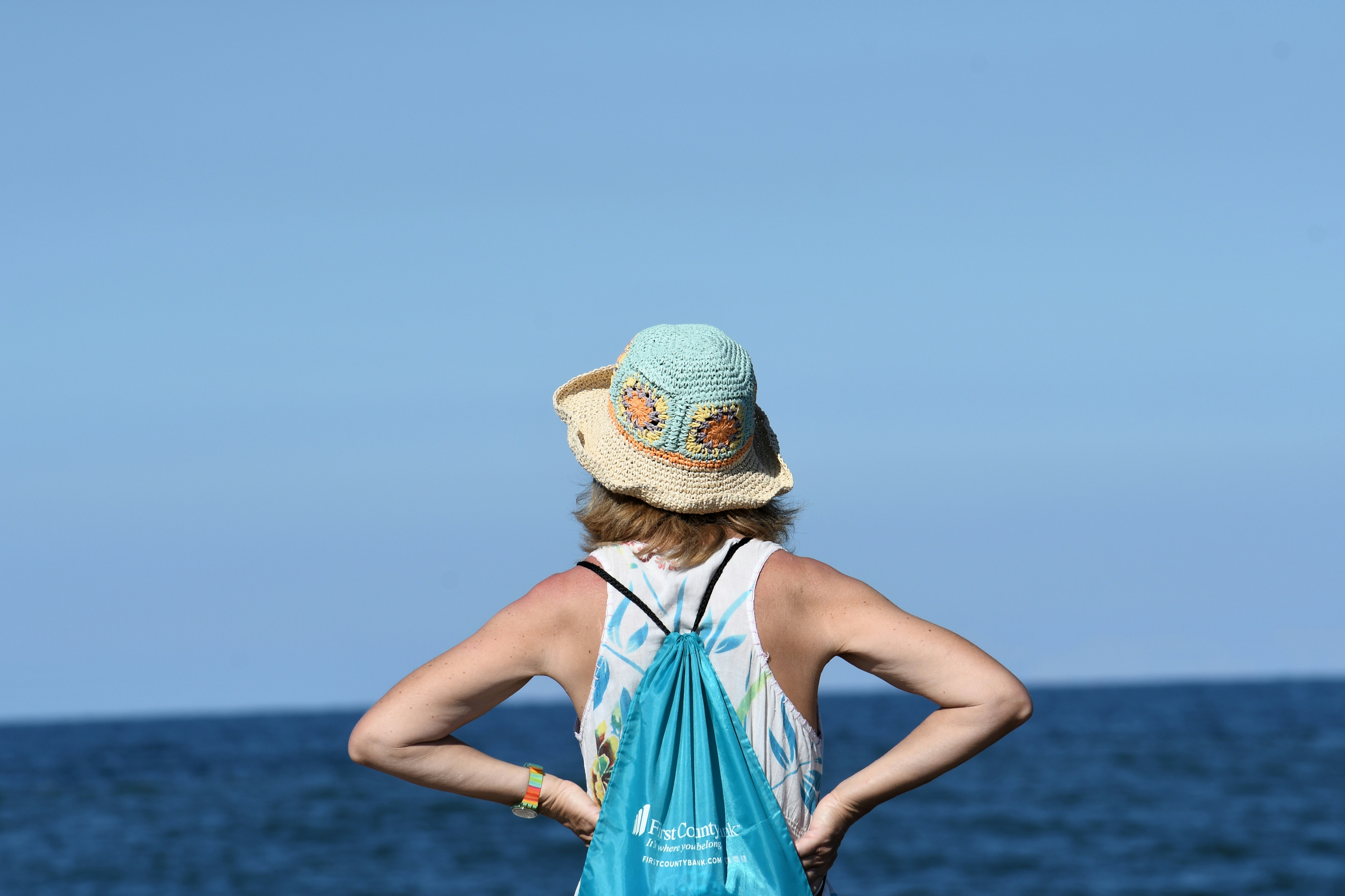 A woman standing on the beach with her back to the camera